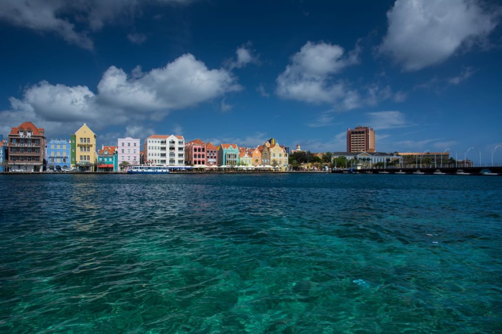 Pastel colored historic Dutch architecture and the floating Queen Emma Bridge in Willemstad Curaçao