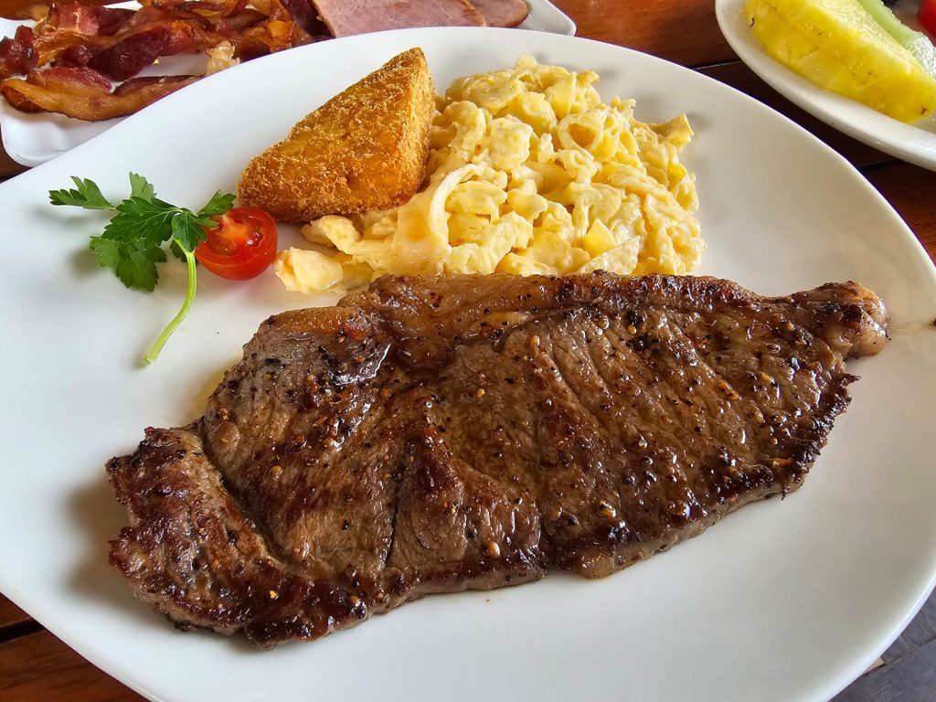 Perfectly cooked medium well steak and eggs served at Aolos restaurant in Sandals Royal Curaçao